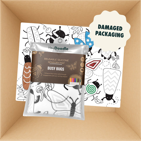 A folded HeyDoodle Australia silicone sensory mat featuring black and white bug illustrations for colouring, packaged in a clear bag with a sticker indicating damaged packaging.