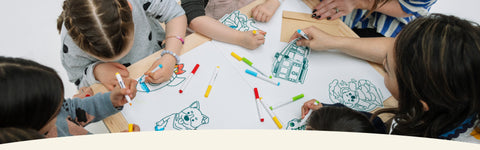 Children colouring forever greeting cards with mini markers on a big table