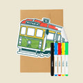 Reusable Gifting Card™ with a tram illustration, an envelope, and five markers on a beige background