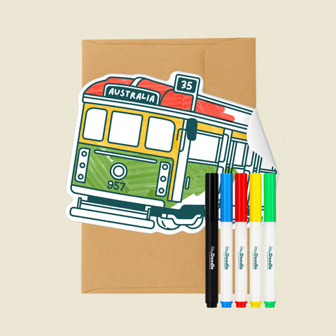 Reusable Gifting Card™ with a tram illustration, an envelope, and five markers on a beige background