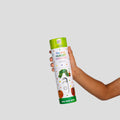 A child’s hand holds the HeyDoodle Australia The Very Hungry Caterpillar™ Mini Colouring & Doodle Mat, which comes in a white cylindrical silicone container decorated with colorful fruit and the iconic green caterpillar. Ideal for storage and travel, this reusable silicone mat invites kids to scribble, doodle, and colour over and over again.