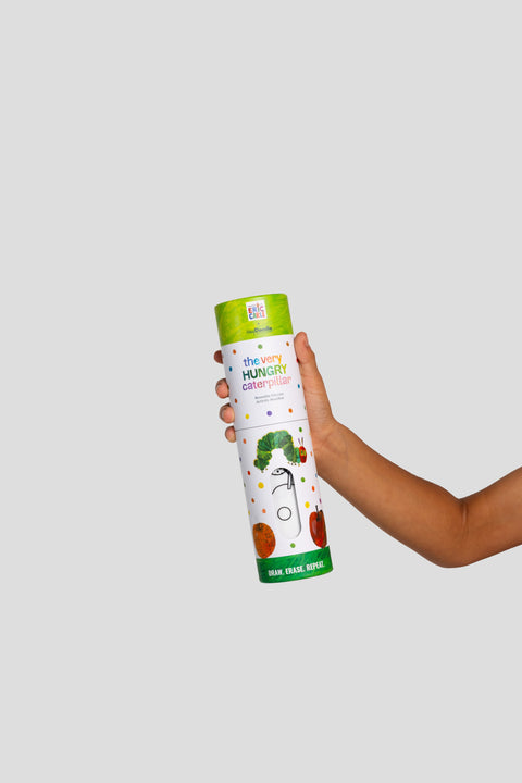 A child’s hand holds the HeyDoodle Australia The Very Hungry Caterpillar™ Mini Colouring & Doodle Mat, which comes in a white cylindrical silicone container decorated with colorful fruit and the iconic green caterpillar. Ideal for storage and travel, this reusable silicone mat invites kids to scribble, doodle, and colour over and over again.