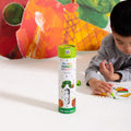A child sits on the floor using colourful markers to decorate a reusable silicone HeyDoodle Australia The Very Hungry Caterpillar™ Mini Colouring & Doodle Mat, surrounded by a lively caterpillar-themed scene filled with bright colours and playful patterns.